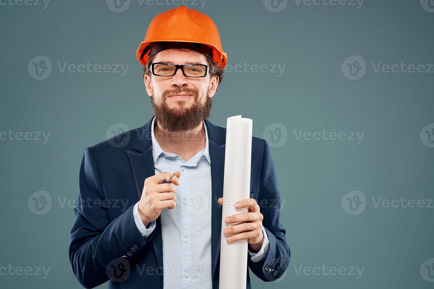 Male engineer wearing a suit in orange paint safety work drawings photo