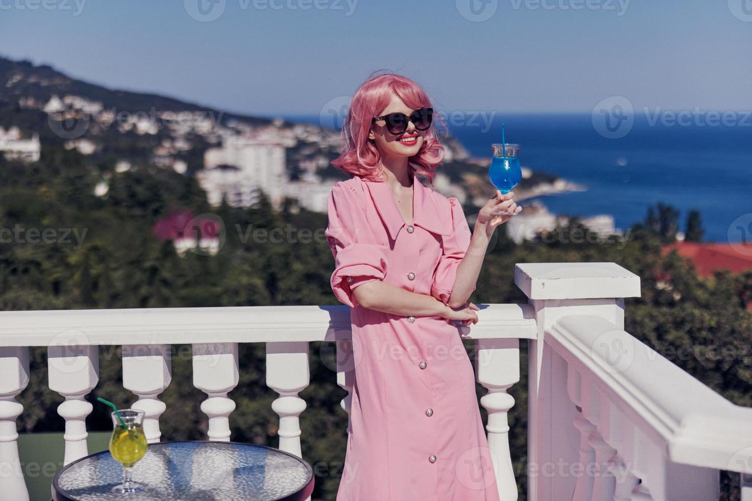 portrait of beautiful woman drinking a cocktail on the terrace Happy female relaxing photo
