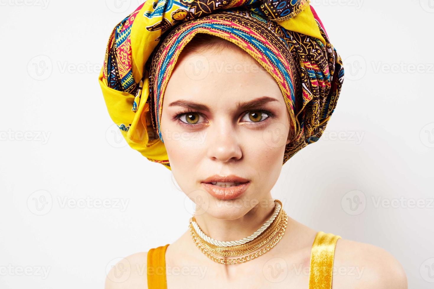 cheerful pretty woman in multicolored turban african style and fashion posing photo