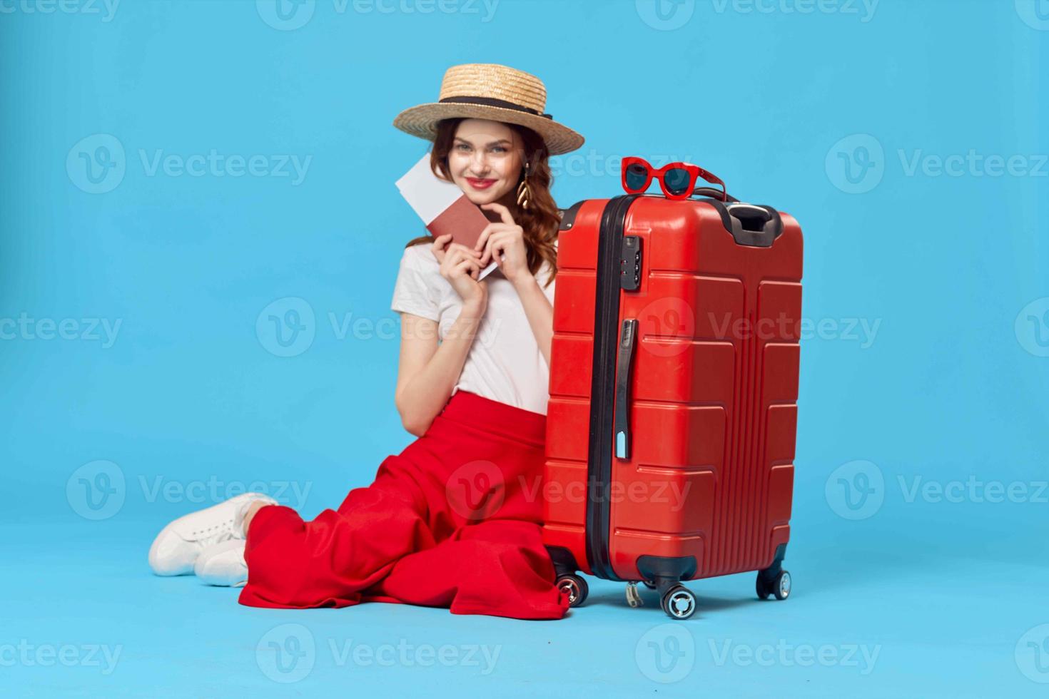 pretty woman tourist wearing hat red suitcase vacation blue background photo