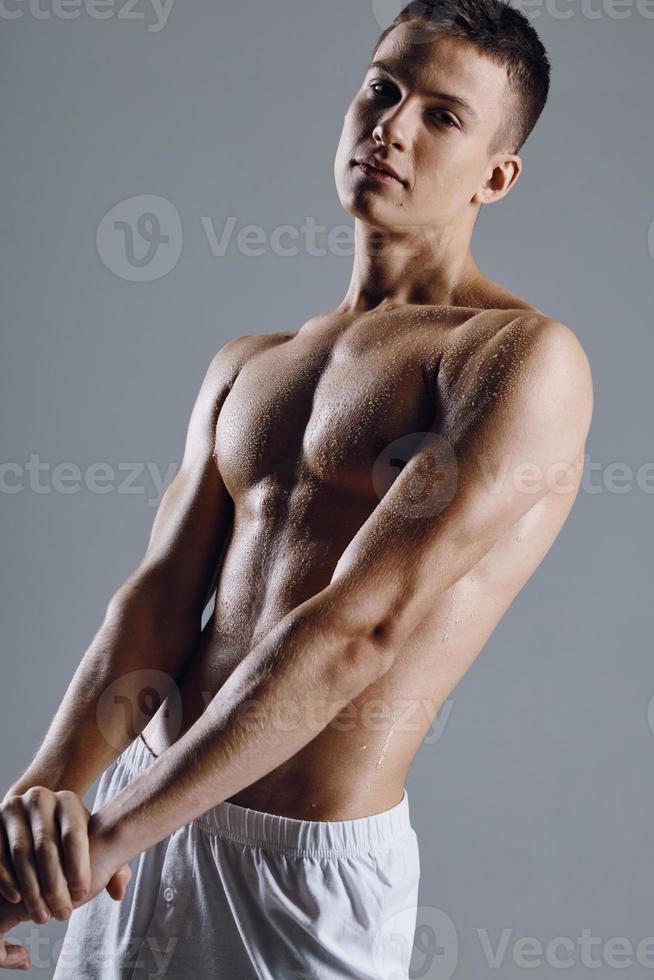 attractive male athlete with pumped up arm muscles on gray background cropped view photo