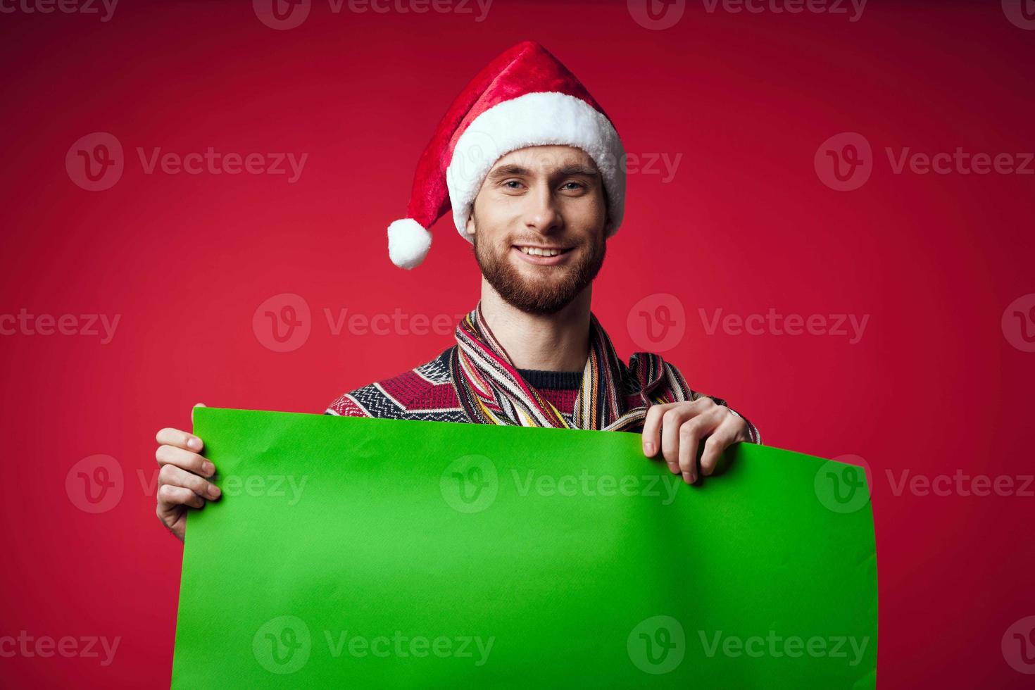 Cheerful man in New Year's clothes advertising copy space red background photo