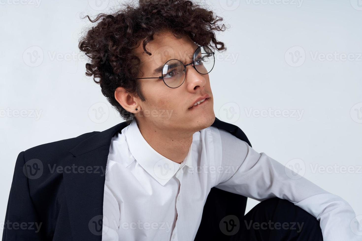 portrait of a curly-haired guy in a shirt in a jacket and glasses photo