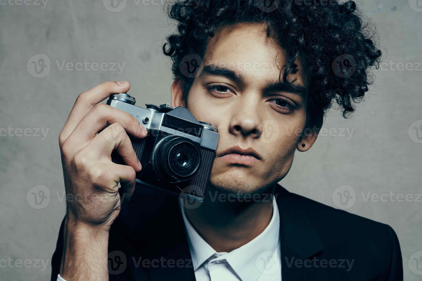 elegant curly man in suit with cameras close up photo