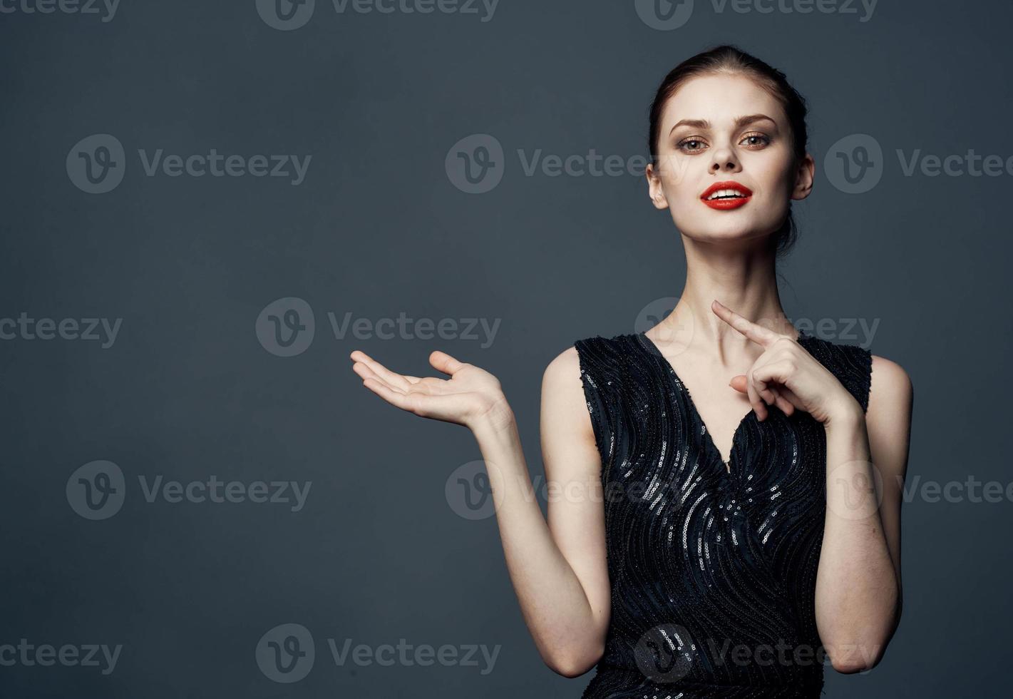 Woman shows her hands to the side on a gray background emotions advertising model photo