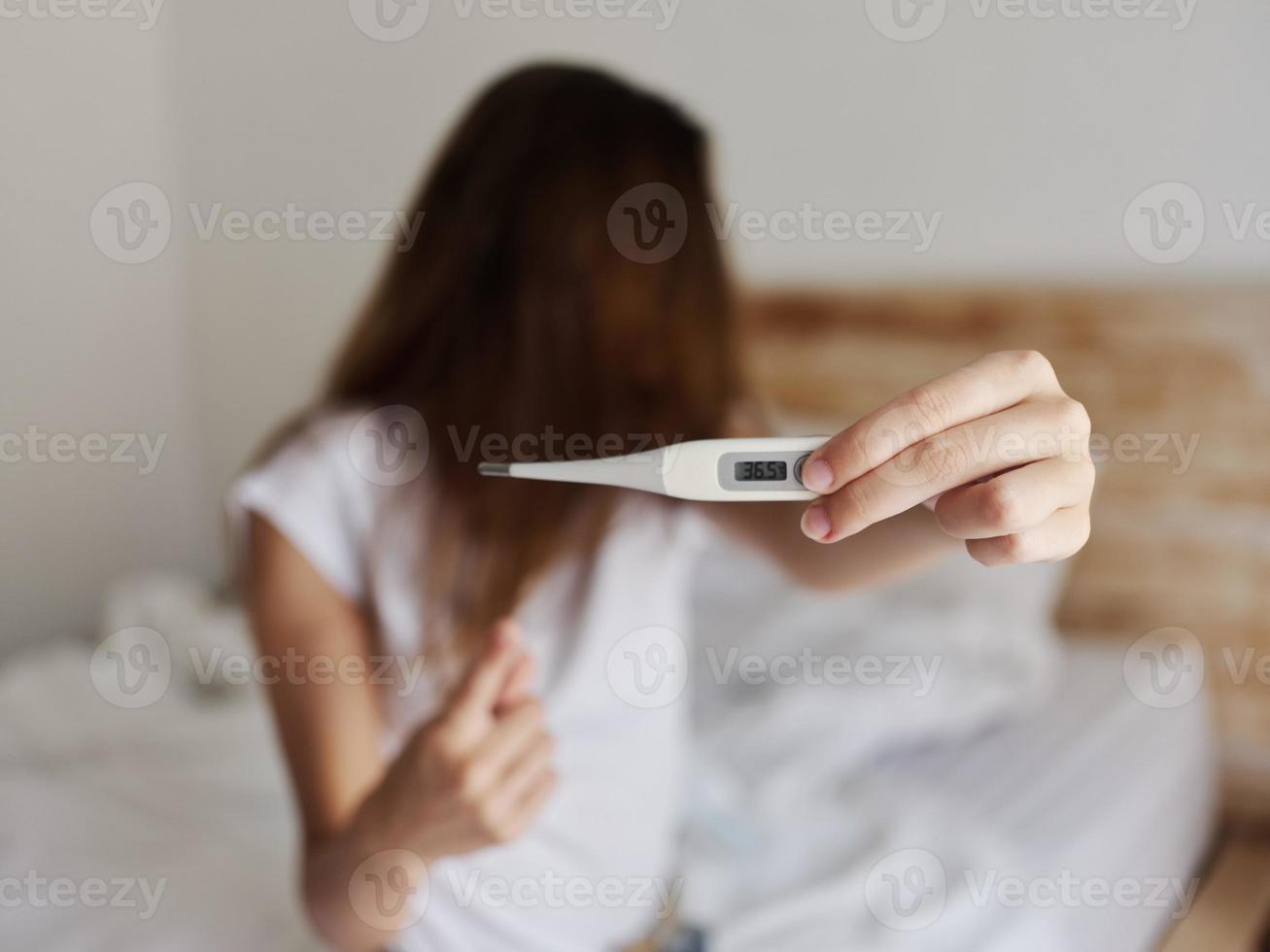 woman showing thermometer close-up looking away photo