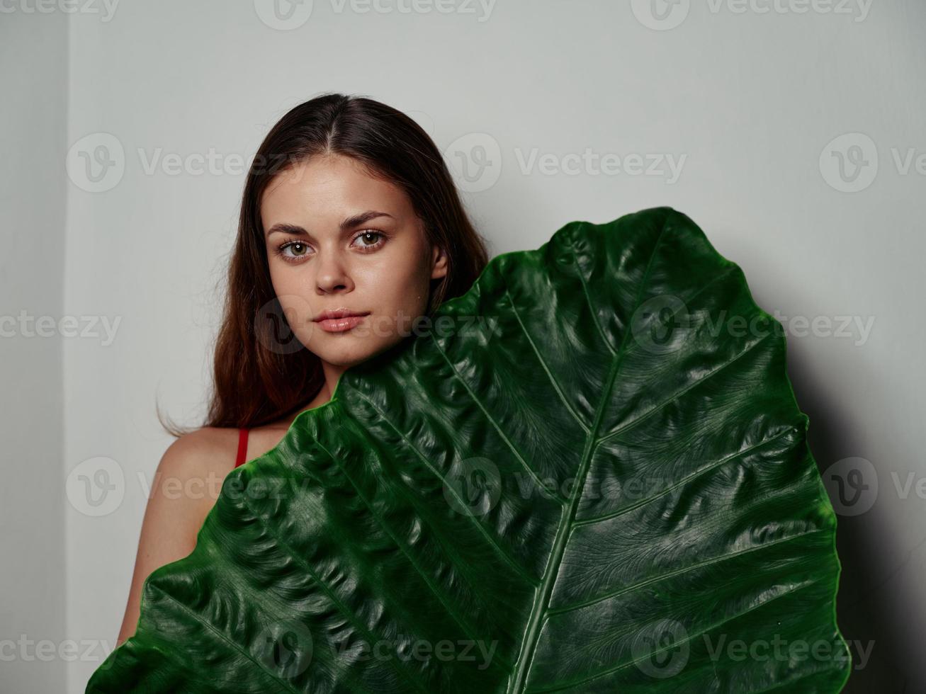 bonito mujer con limpiar piel y verde palma hoja ligero antecedentes modelo foto