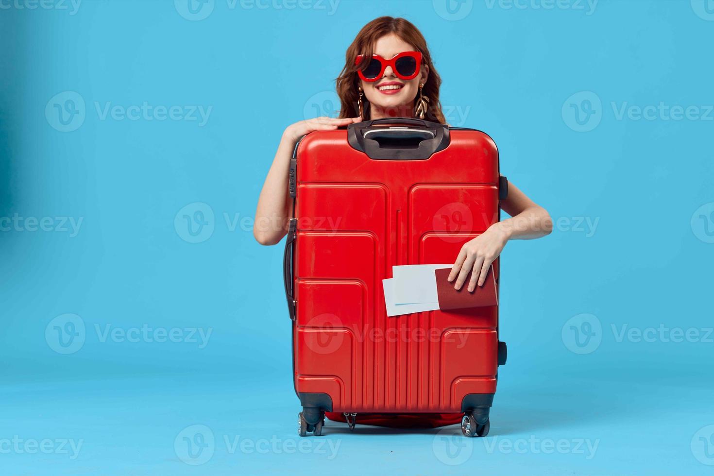 woman with red suitcase sitting on the floor passport and plane tickets lifestyle photo