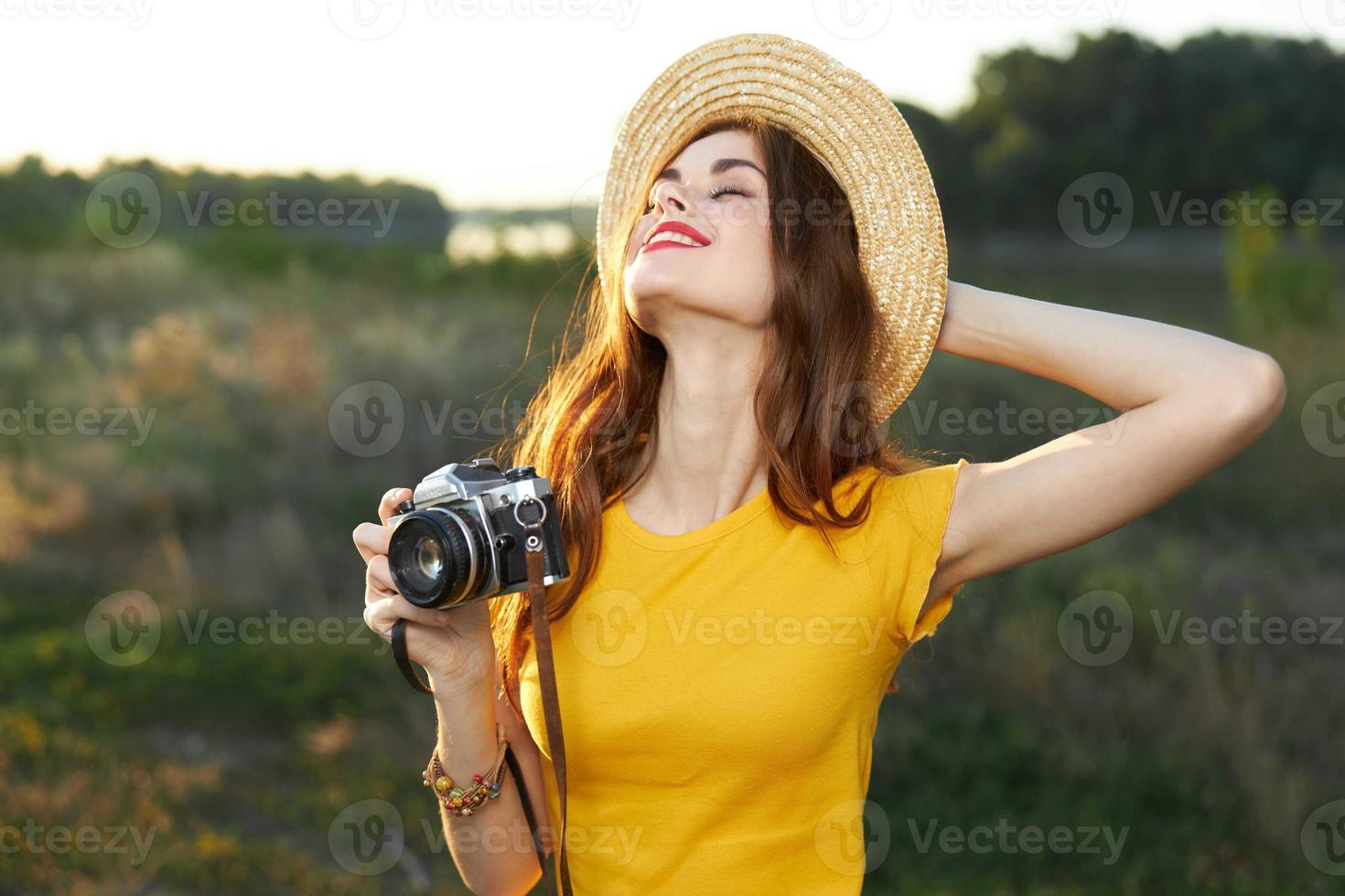 Woman looking up eyes closed camera hat yellow t-shirt nature photo