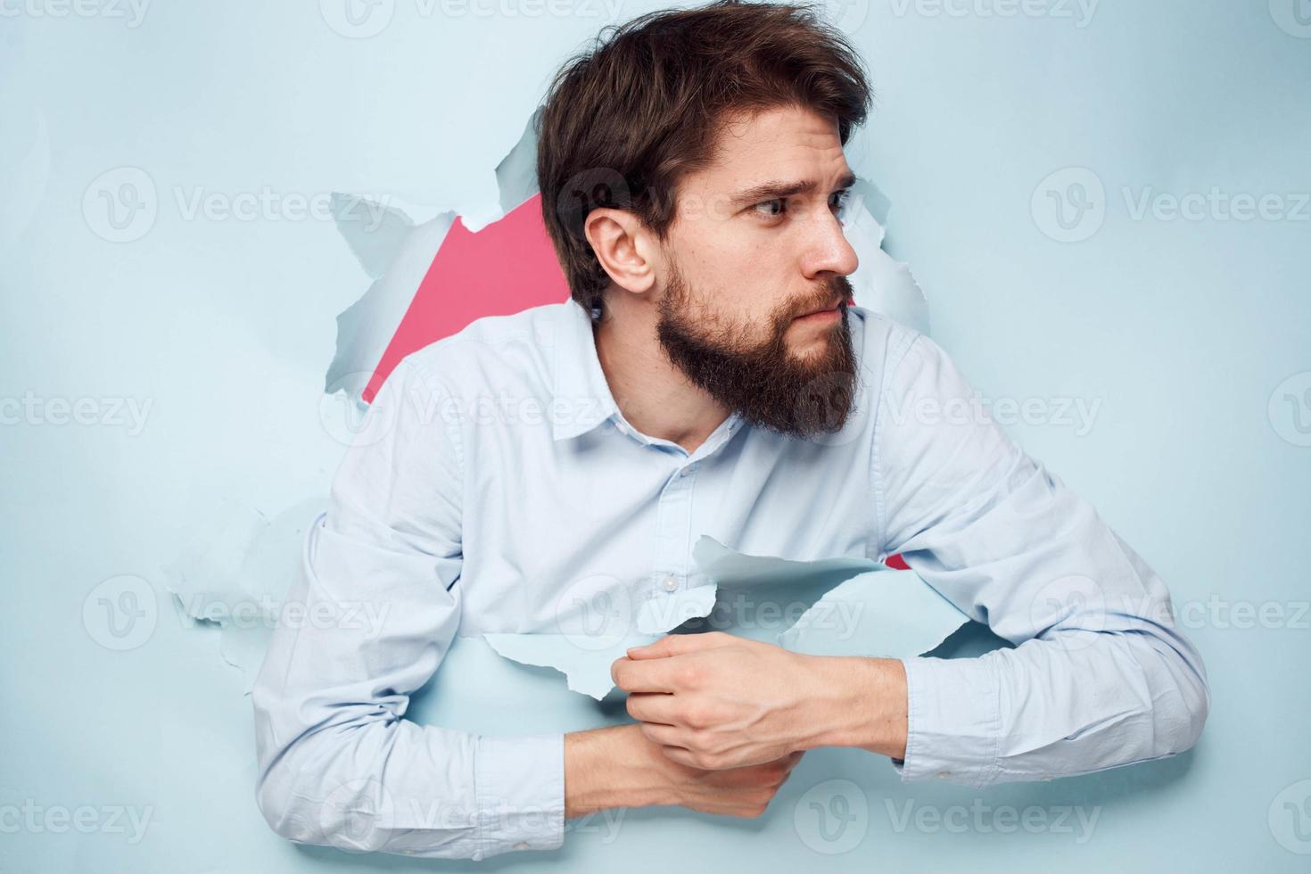 A business man in a shirt peeks out from behind a wall with emotions stress work photo