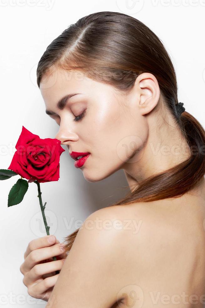 niña con flor cerrado ojos rojo labios foto