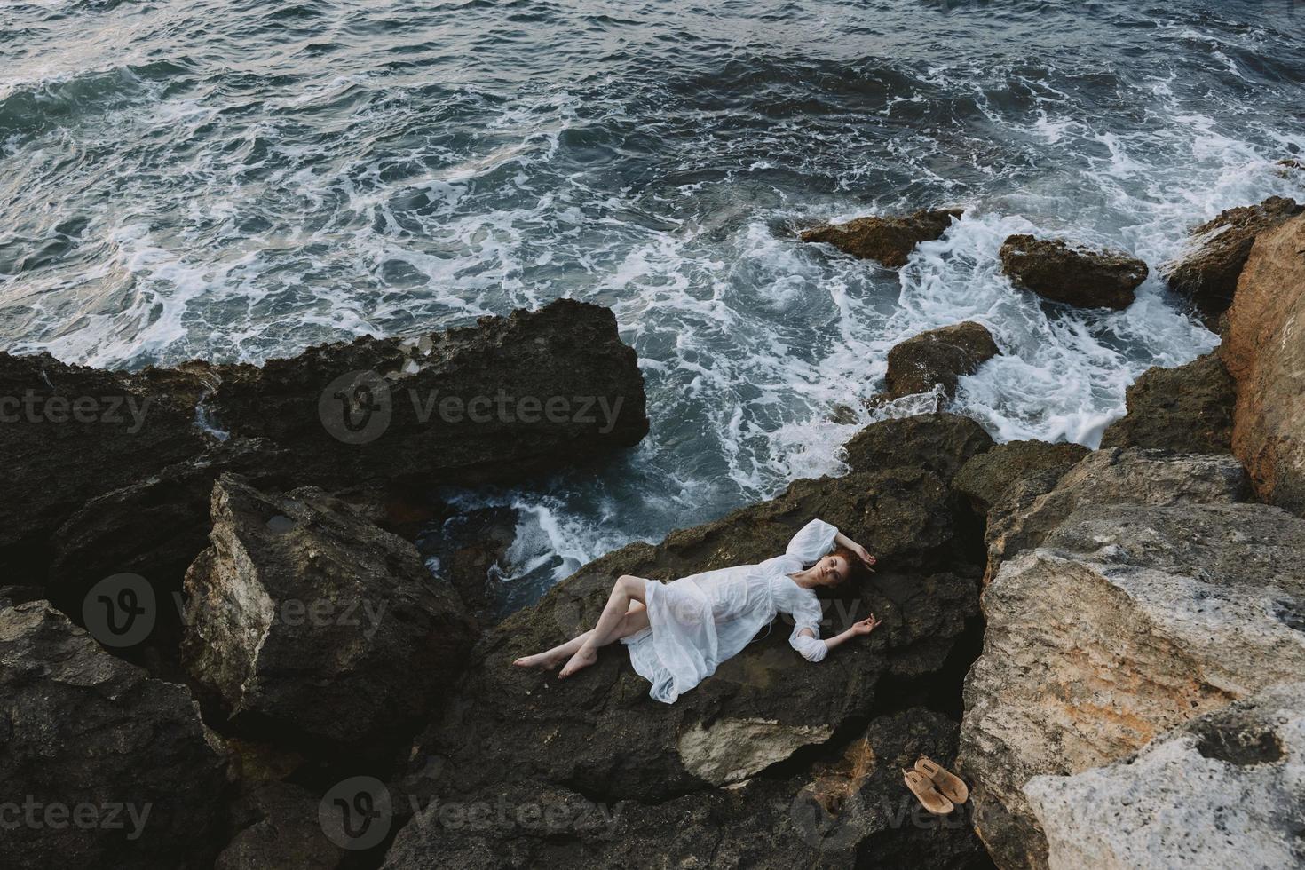 Beautiful bride in white wedding dress on sea shore wet hair view from above photo