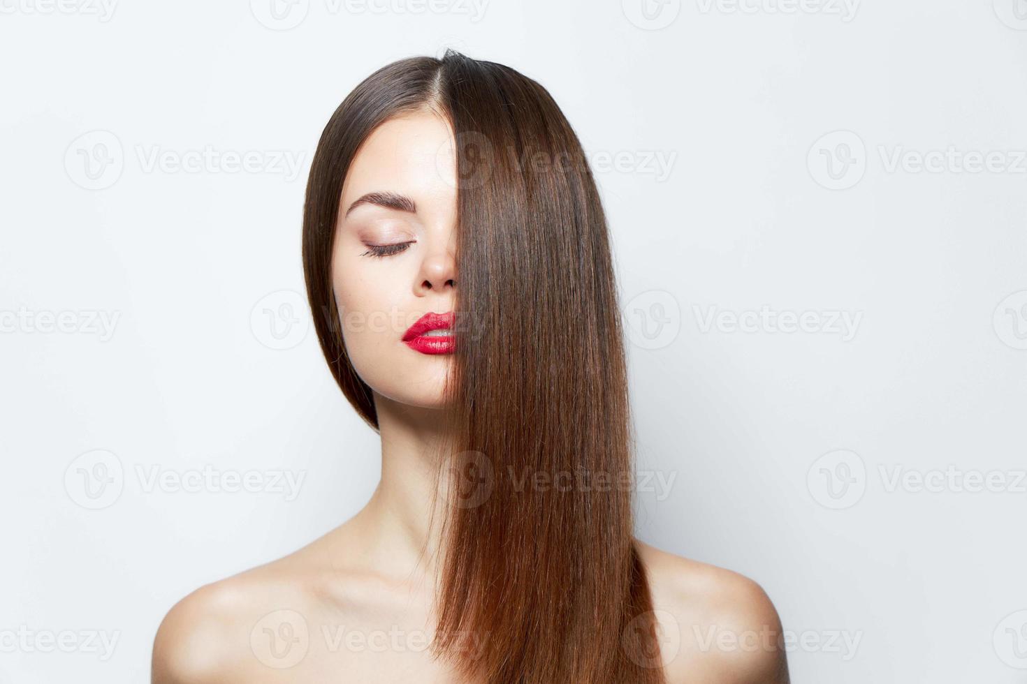 atractivo mujer pelo cubre medio de el rostro, cerrado ojos brillante maquillaje foto