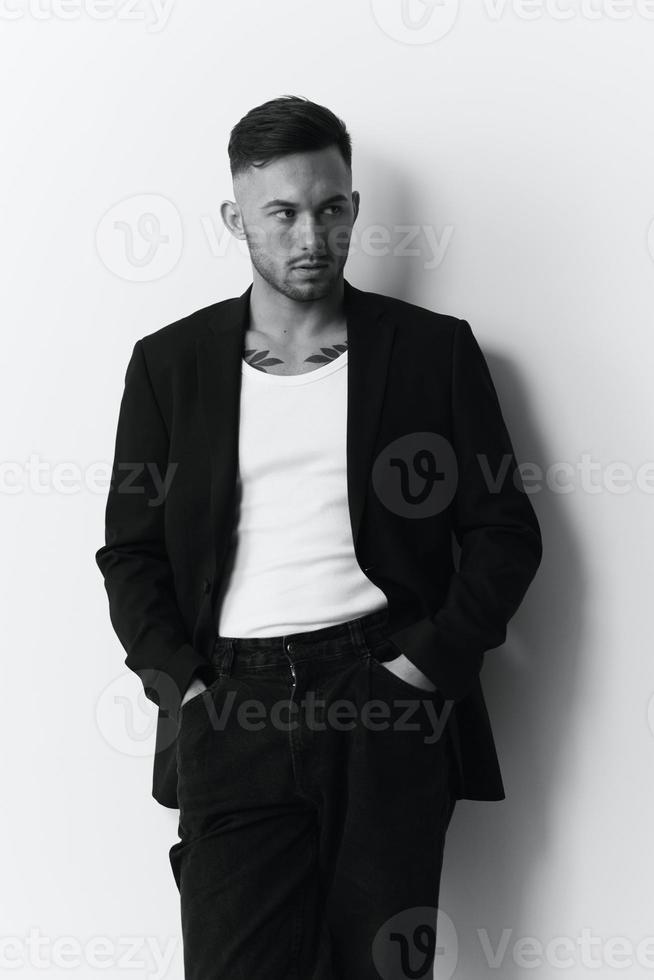 Modelling snapshots. Evil self-confident attractive handsome man in classic suit hold hand on pocket posing isolated in white studio background. Black and White concept. Fashion offer. Copy space photo