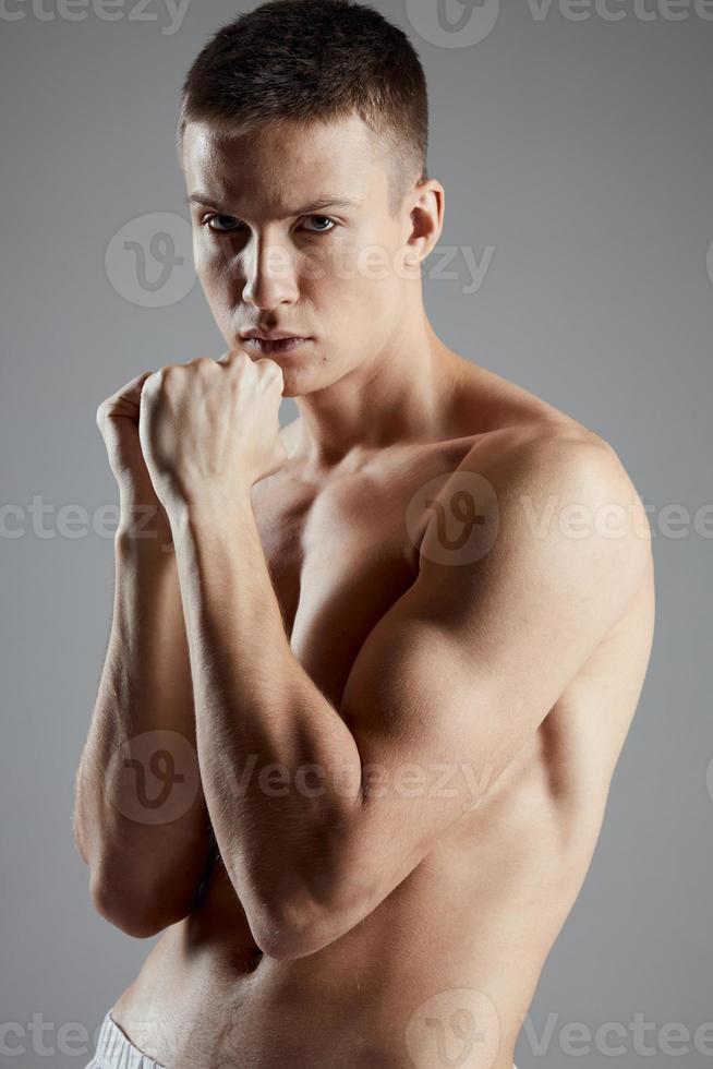 boxer with inflated arm muscles biceps Sport Fitness gray background photo