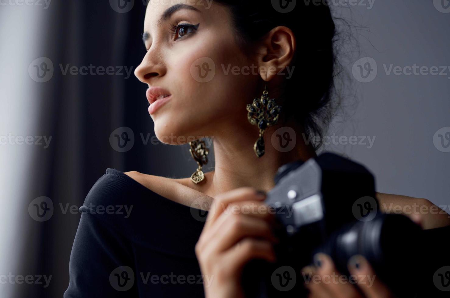 beautiful woman holding a camera near the window decoration fashion lifestyle studio photo