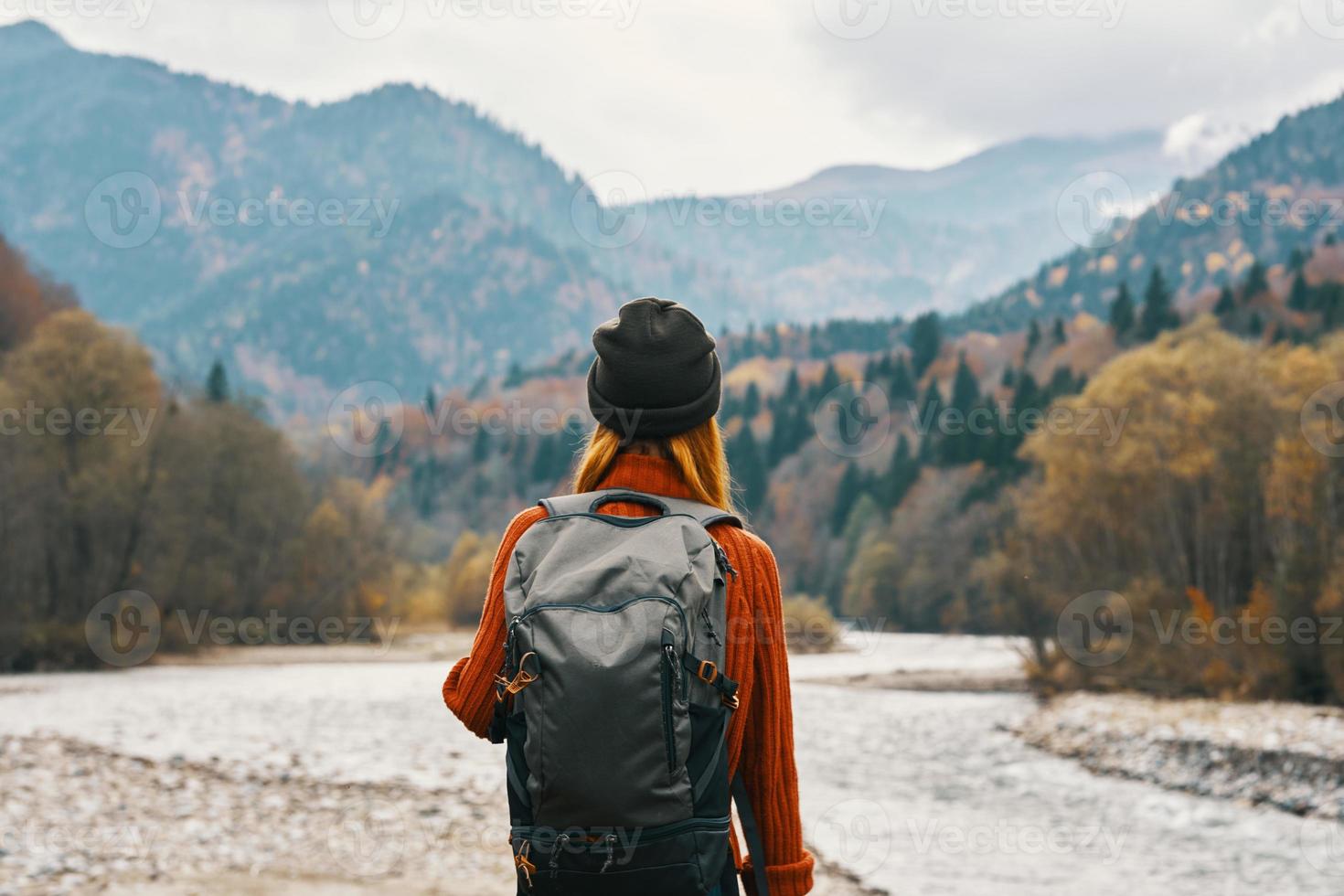 woman hiker with a backpack rest in the mountains in nature near the river photo