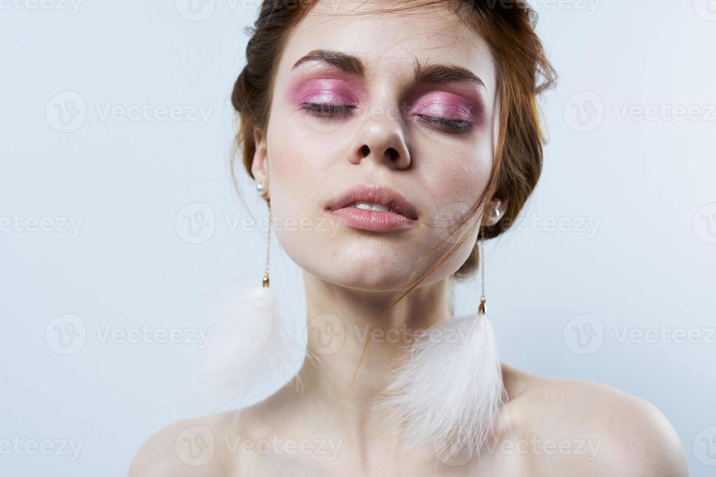woman with bright makeup jewelry fluffy earrings close-up photo