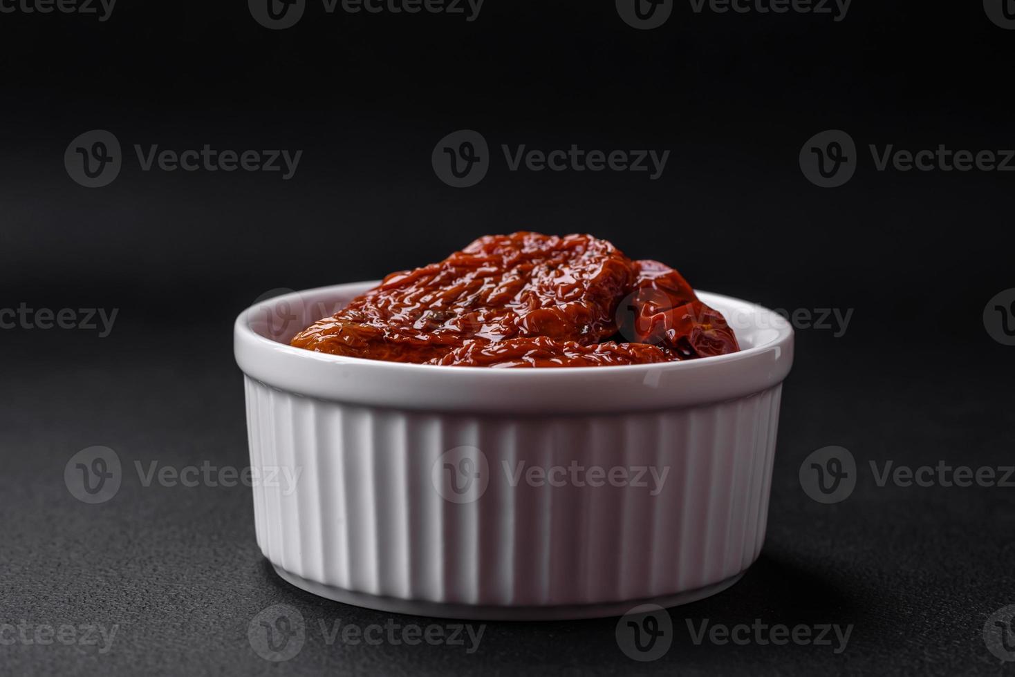 Delicious sun dried tomatoes in oil in a white ceramic bowl photo