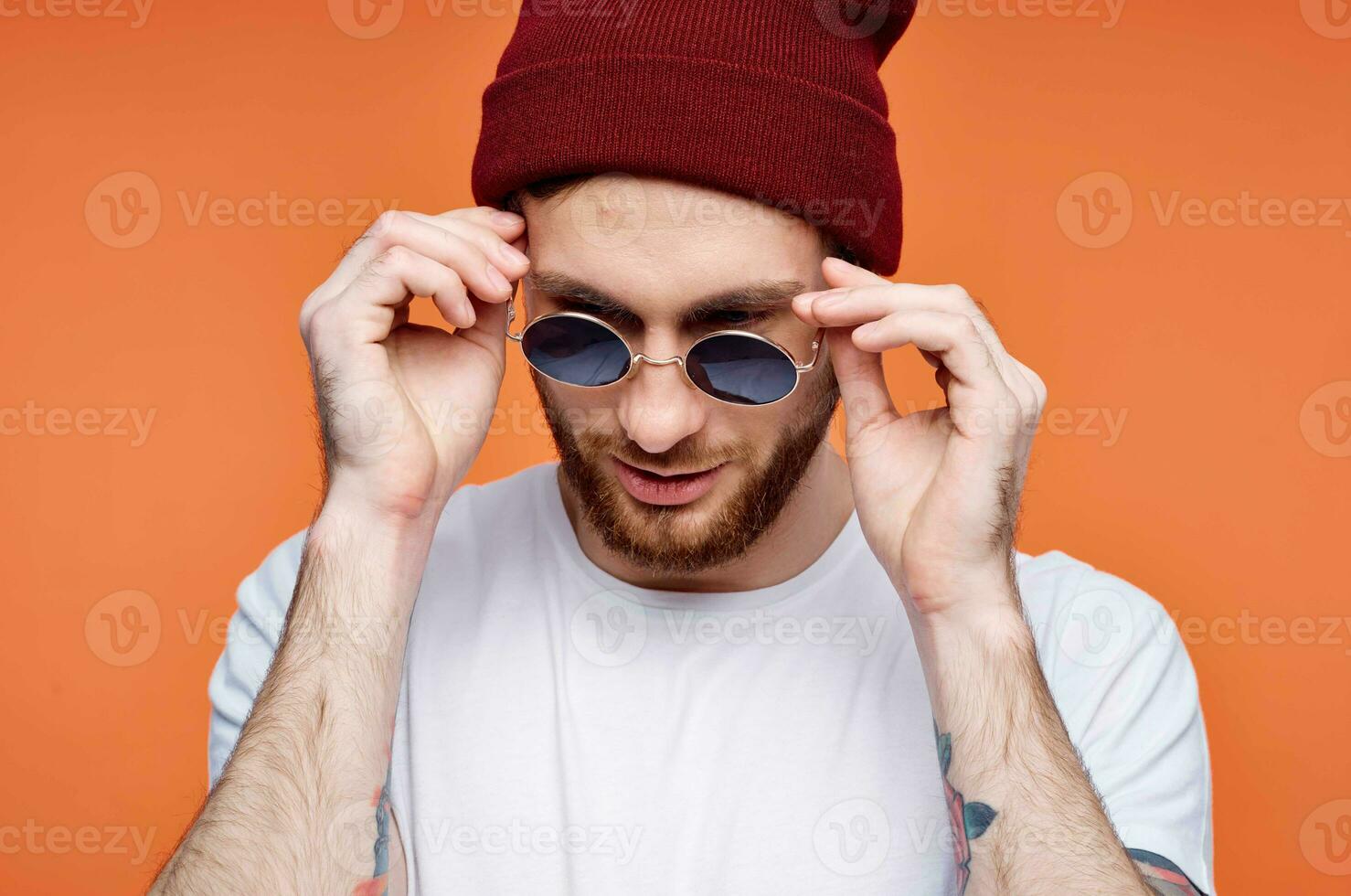 Cheerful man in sunglasses holding a flower orange background photo