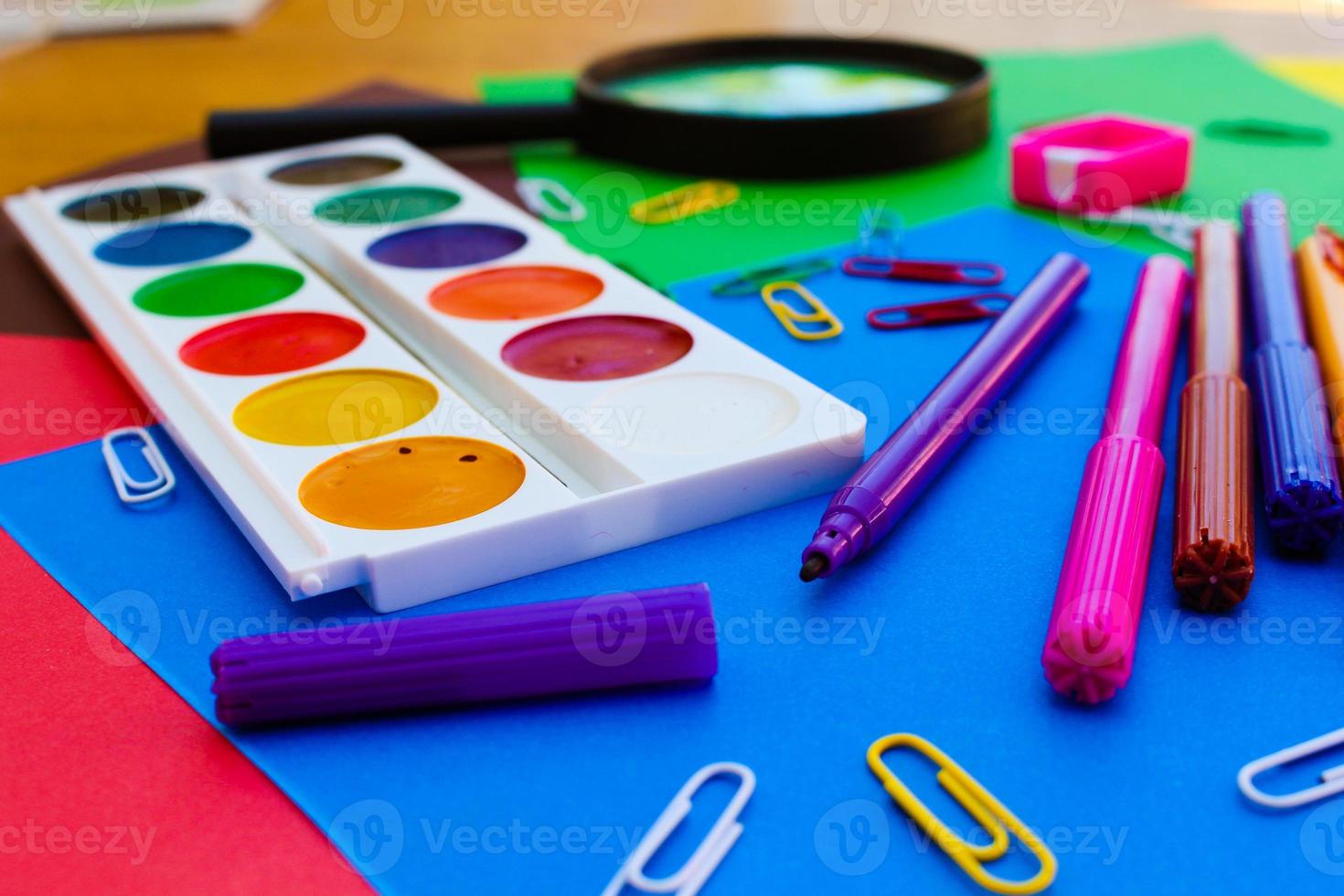 Stationery objects. School and office supplies on the background of colored paper. photo