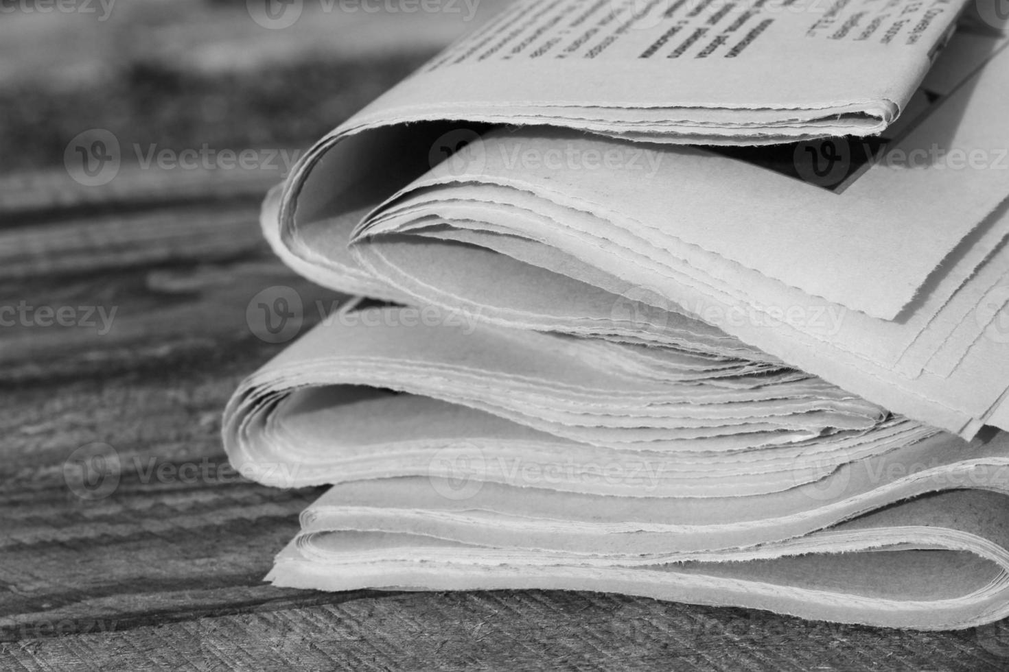 Newspapers on old wood background. Black and white shot. photo