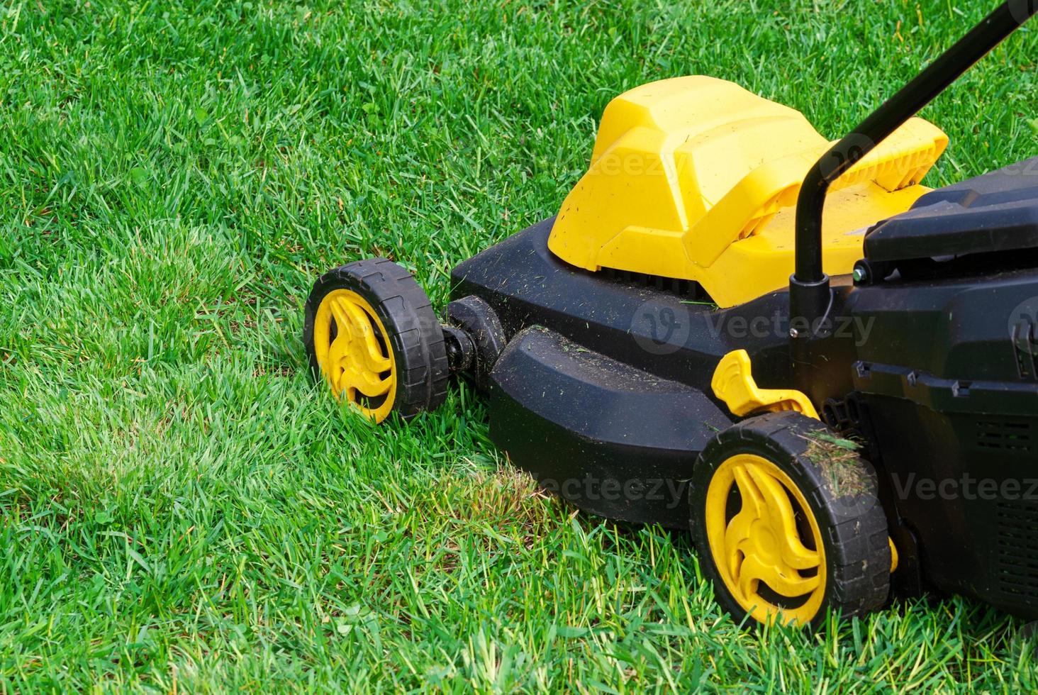 lawnmower working on green grass photo