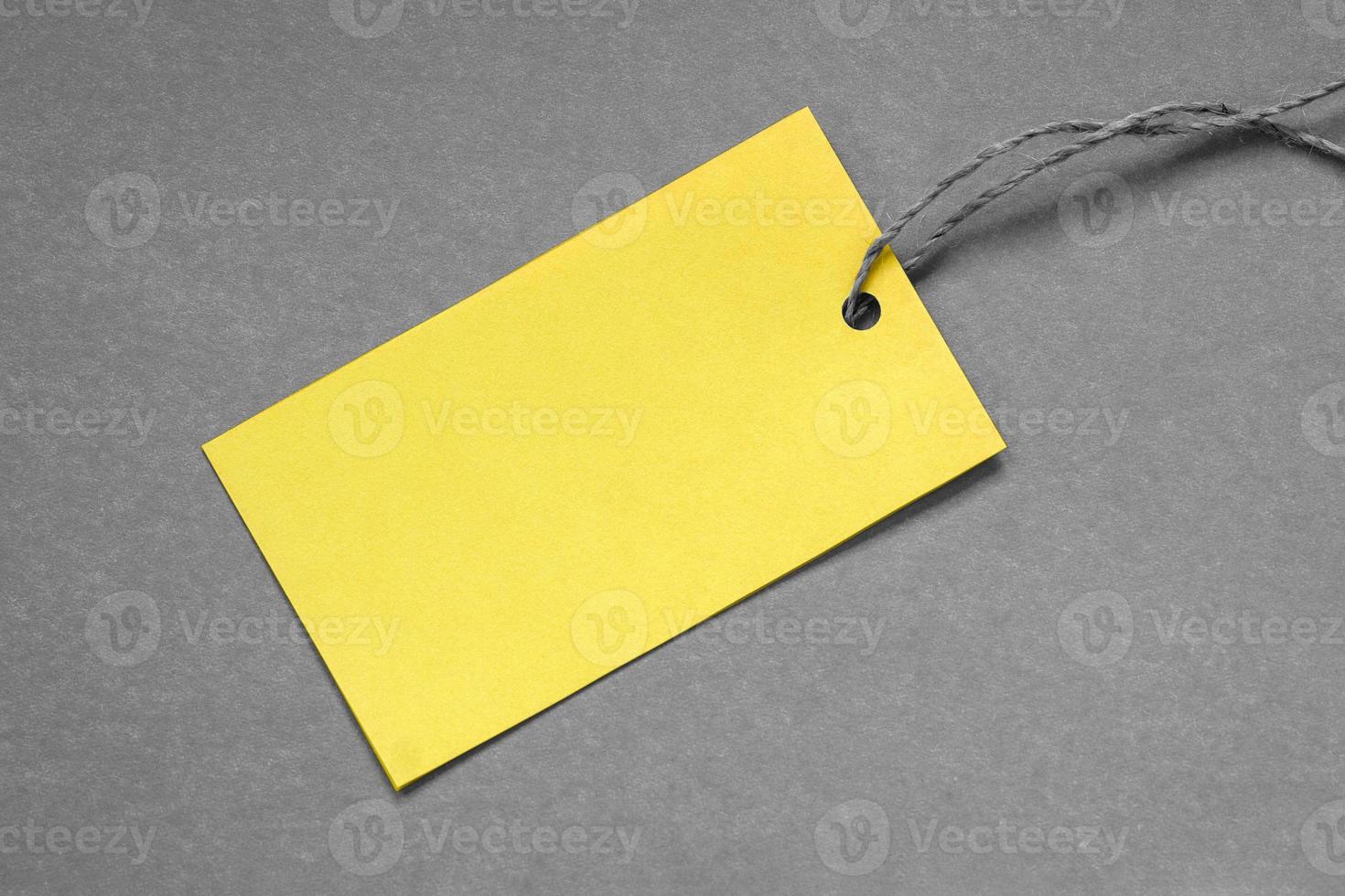 Yellow paper tag on gray background, copy space photo
