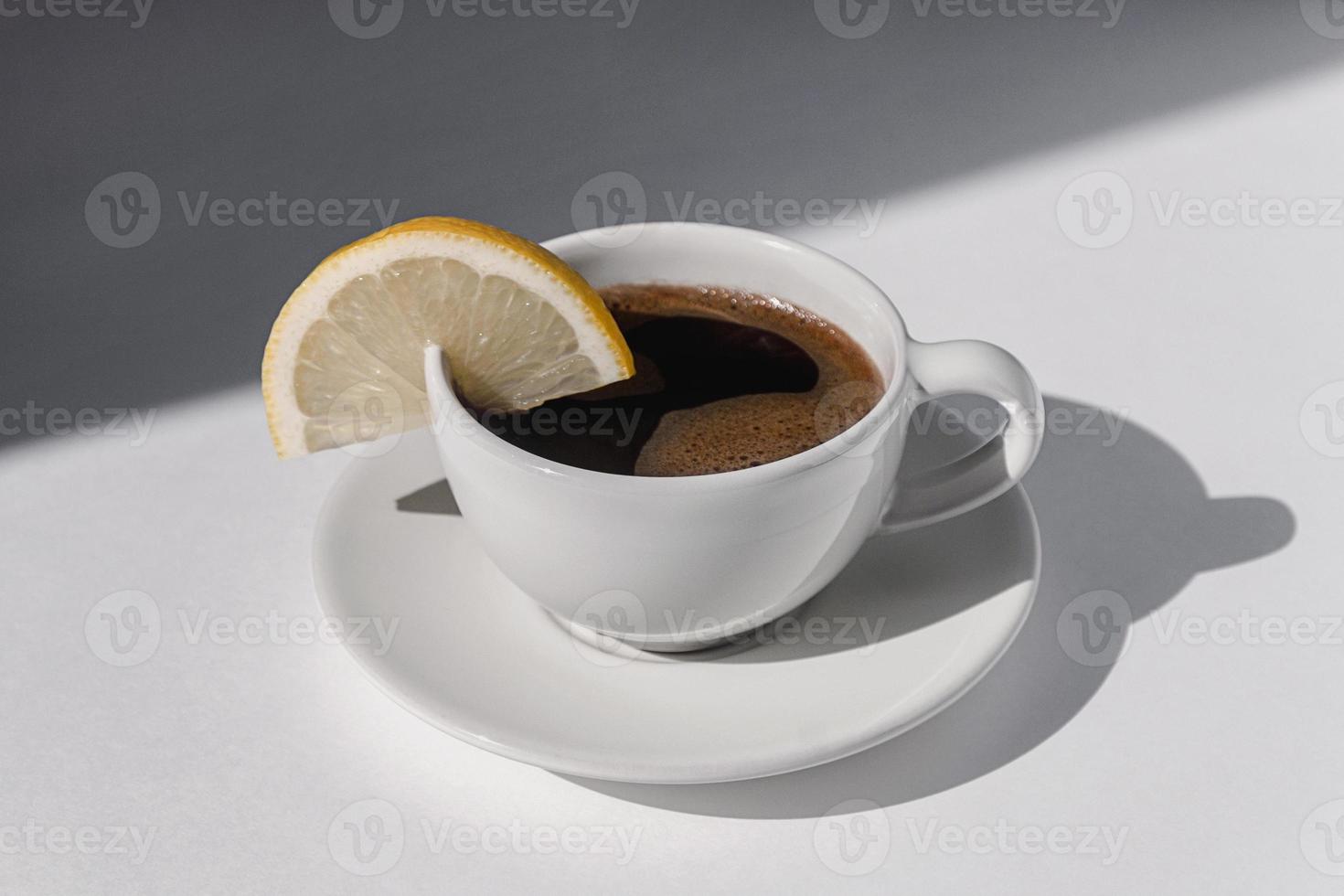 Coffee cup with espresso served with lemon on white background with