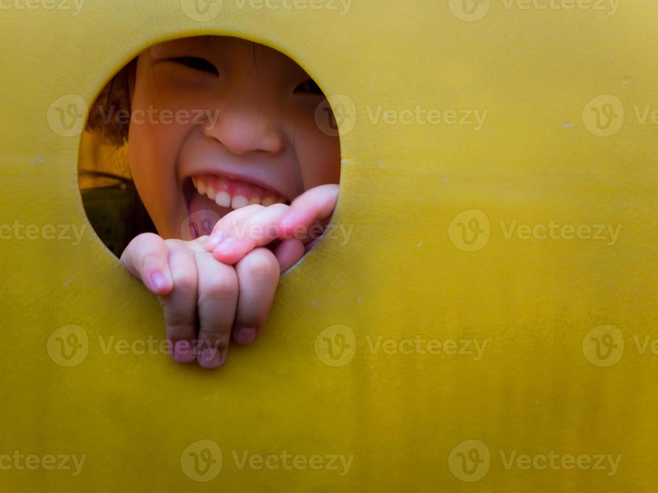 niña asiática disfruta jugando en el patio de recreo foto