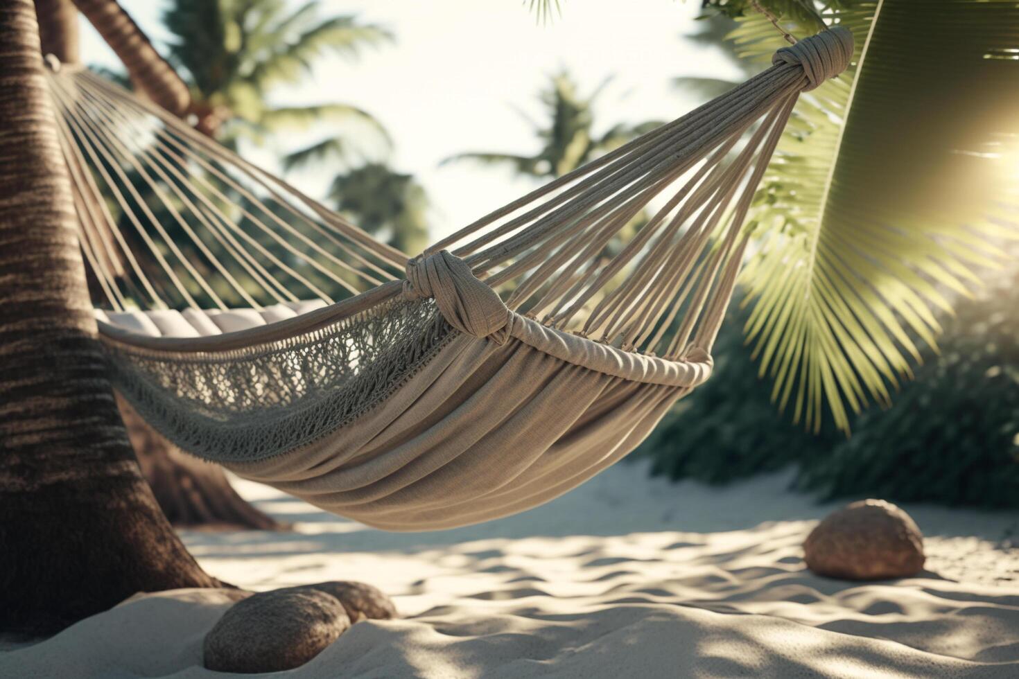 A hammock between two palm trees on a beach, photo