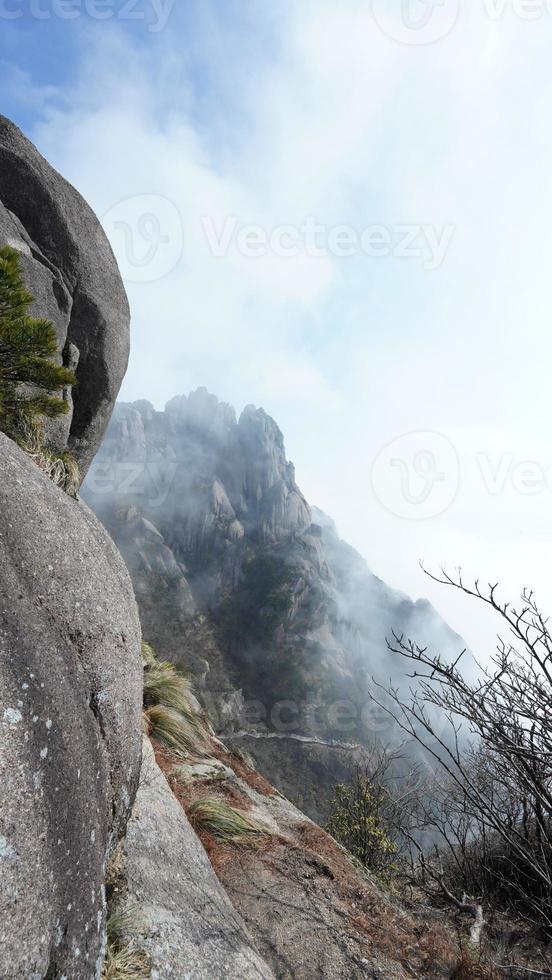 los hermosos paisajes montañosos con el bosque verde y el acantilado rocoso en erupción como fondo en el campo de china foto