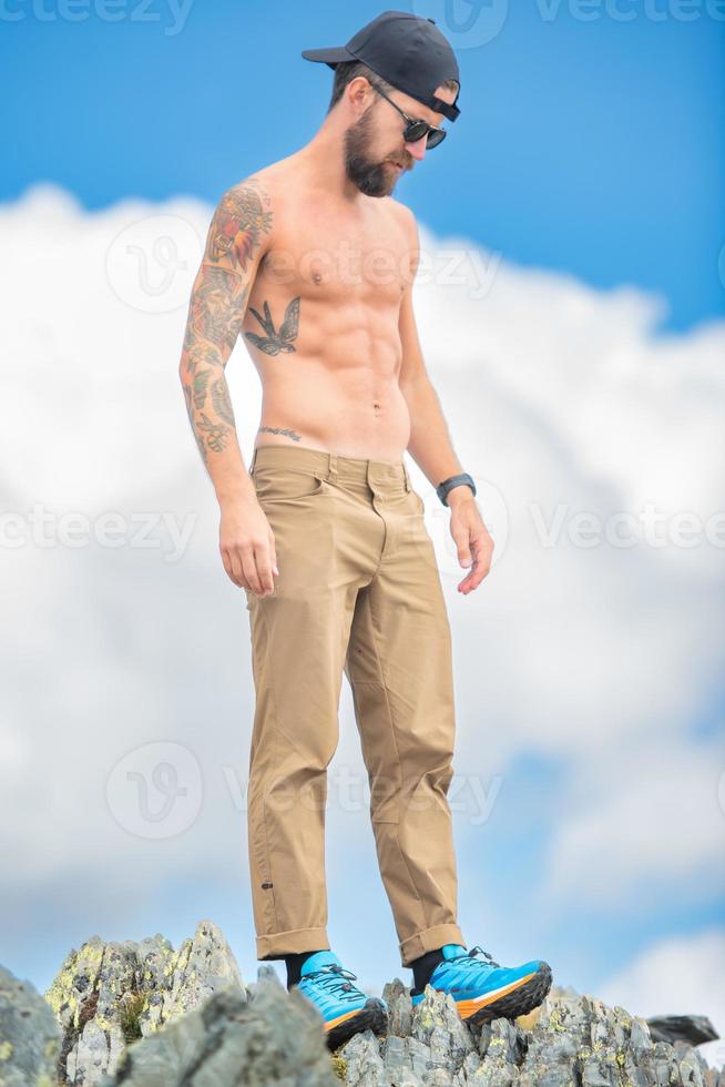A young man bare backed in the mountains photo