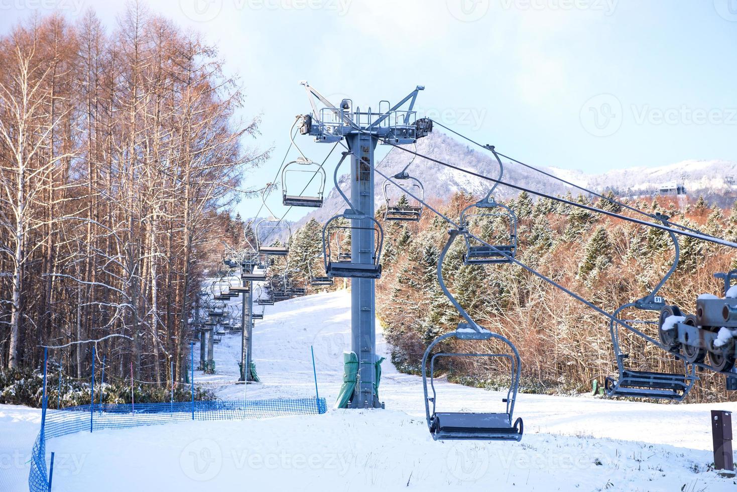 Snowboarders and skiers riding up a ski lift photo