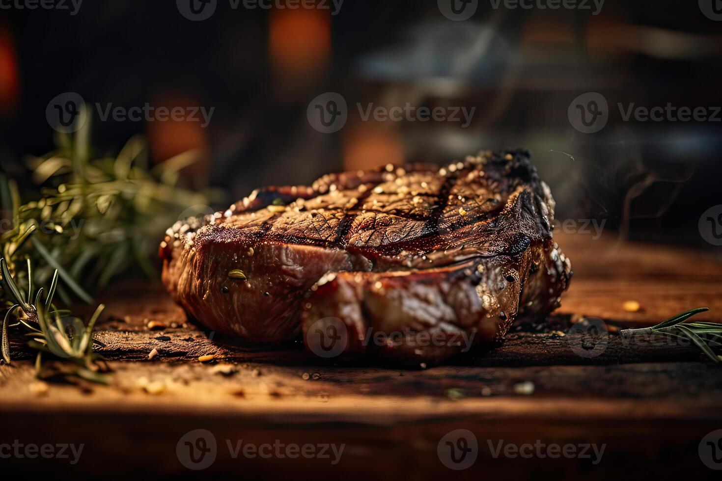 Grilled ribeye beef steak served on wooden board with rosemary, grilled garlic, fork and knife on wooden table. . photo