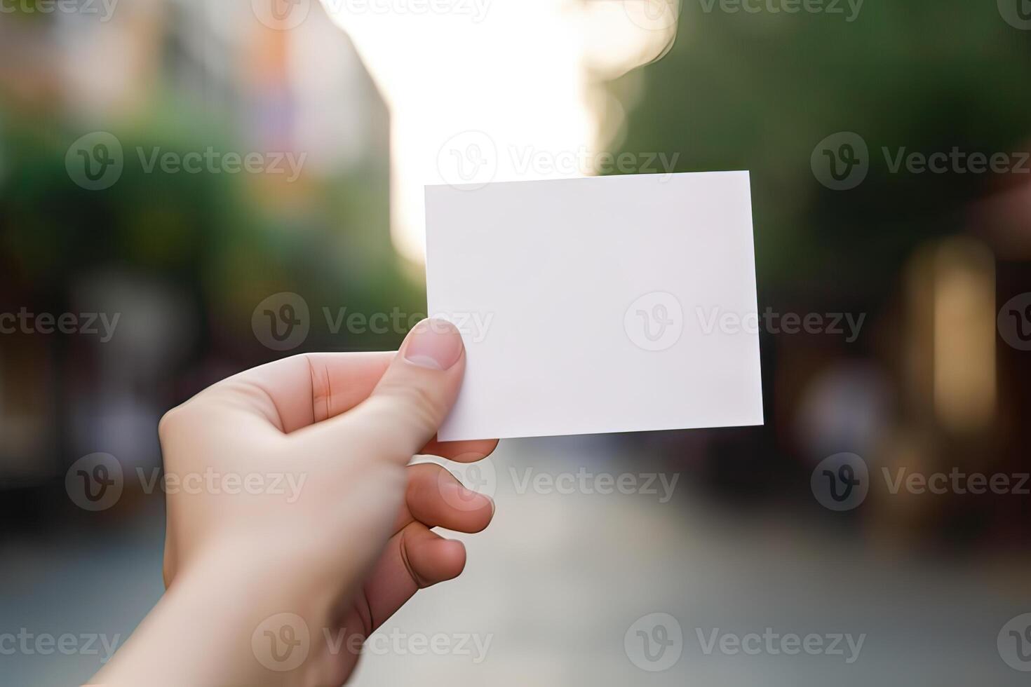 hand holds blank white paper with blurred background. free copy space. photo