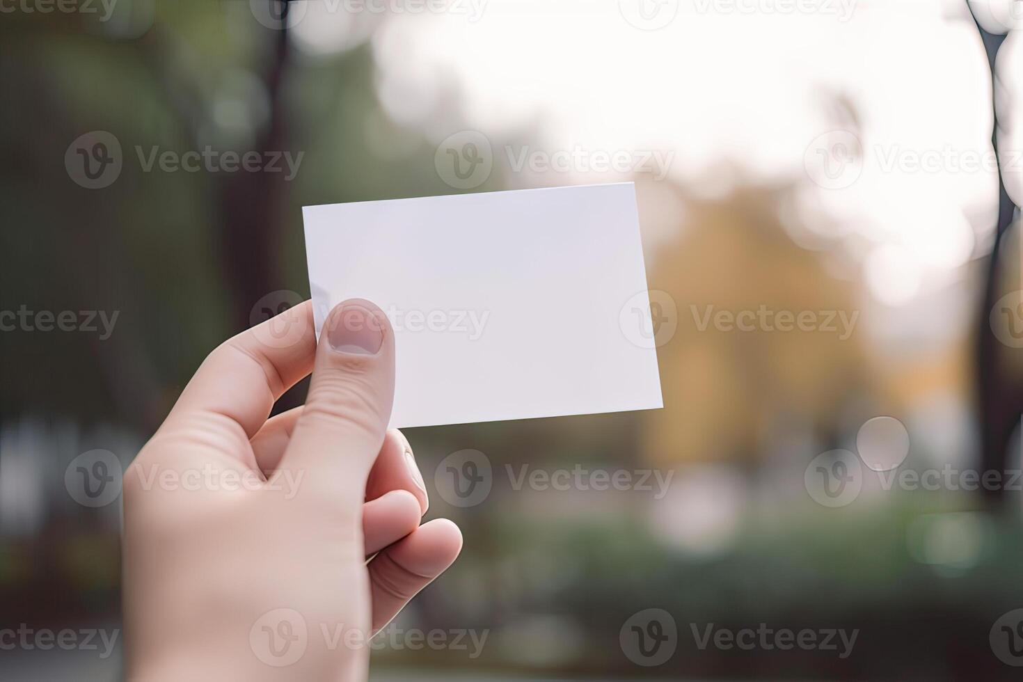 hand holds blank white paper with blurred background. free copy space. photo