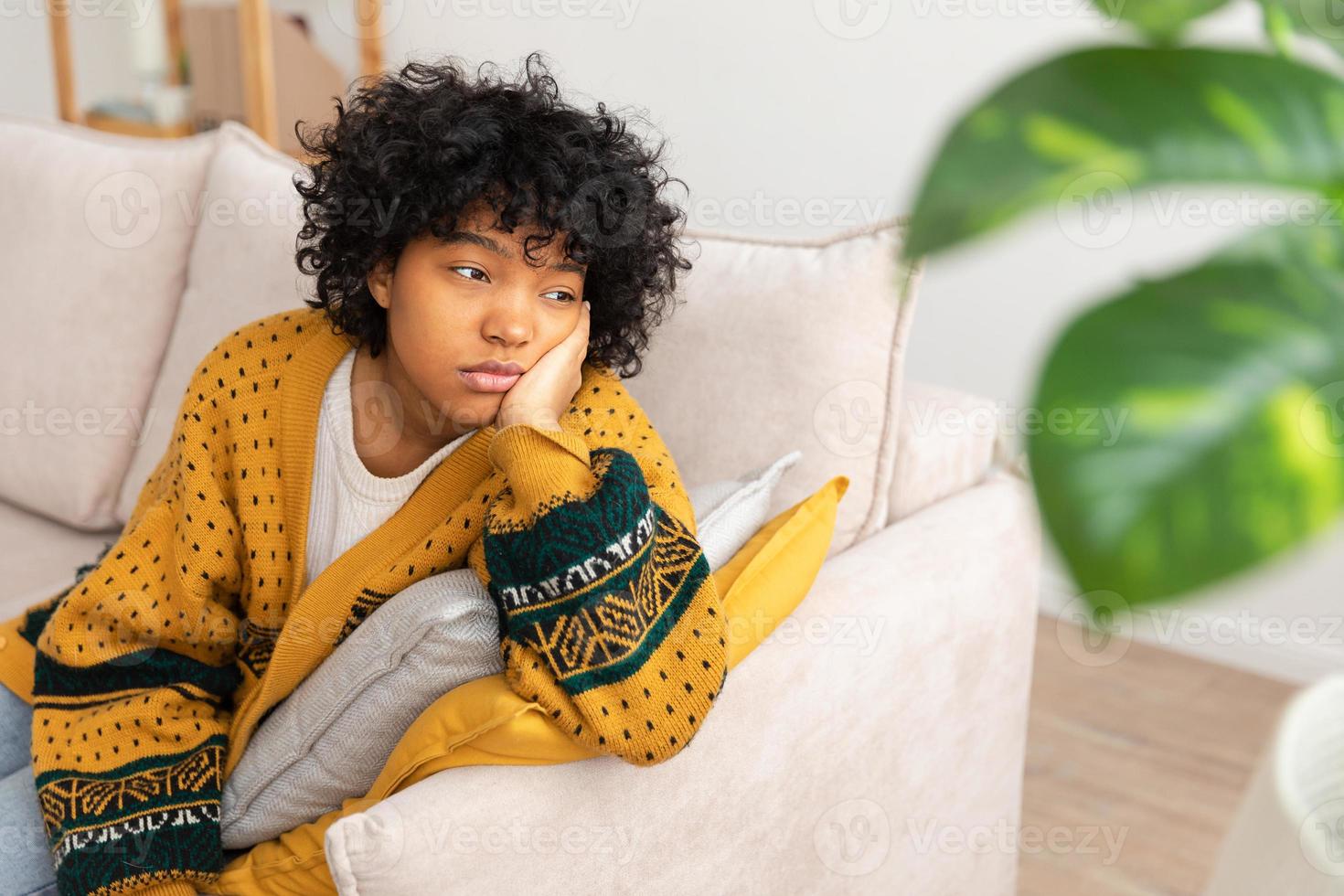 African american sad thoughtful girl at home. Young african woman feels depressed offended lonely upset suffers from abuse harassment heartbreak. Grieving violence victim has psychological problem. photo