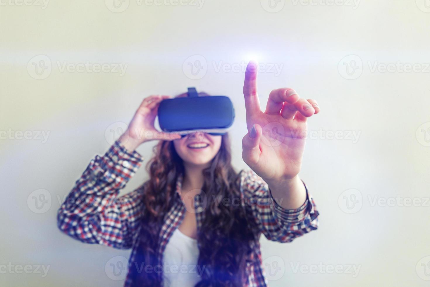 Smile young woman wearing using virtual reality VR glasses helmet headset on white background. Smartphone using with virtual reality goggles. Technology, simulation, hi-tech, videogame concept. photo
