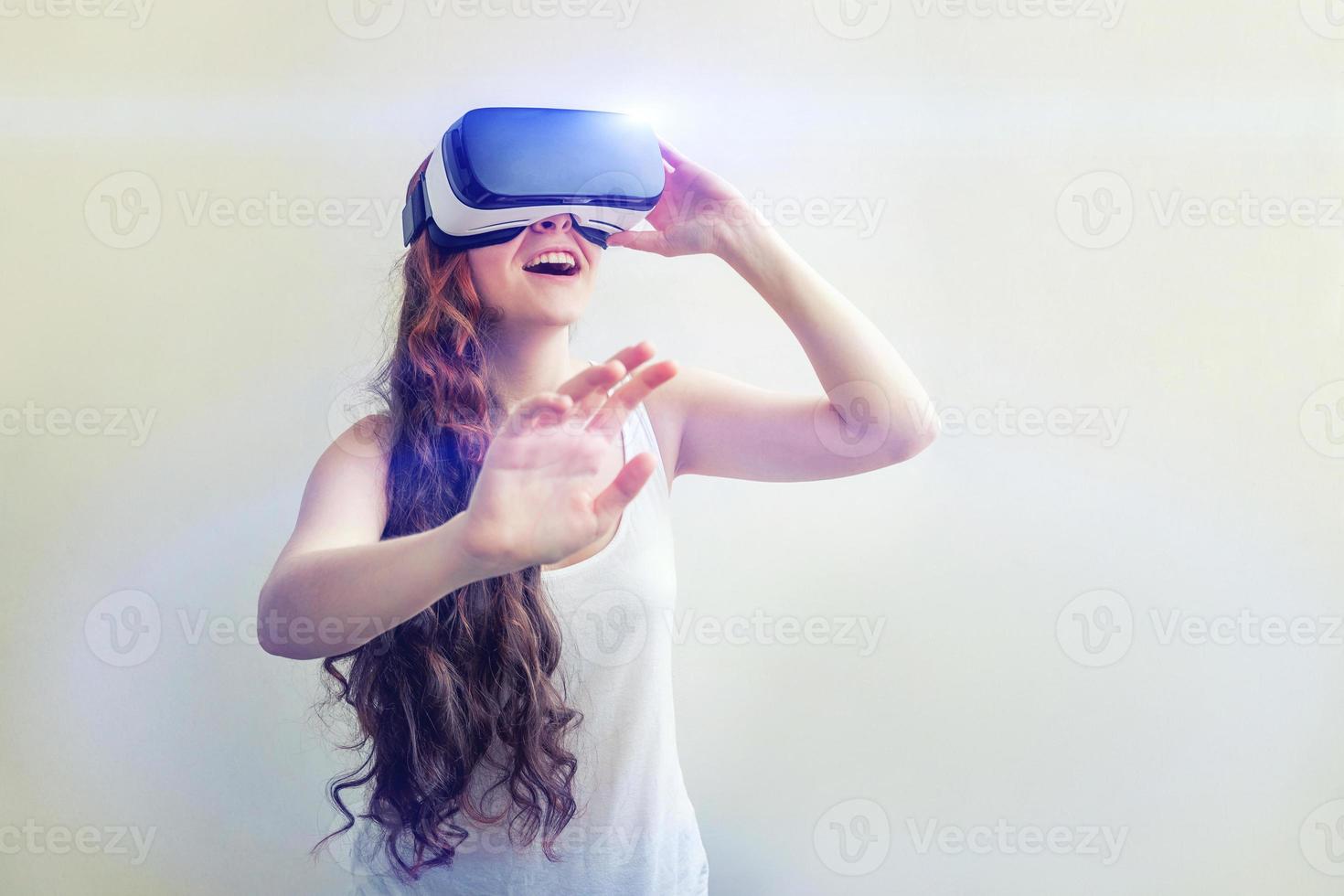 sonrisa joven mujer vistiendo utilizando virtual realidad vr lentes casco auriculares en blanco antecedentes. teléfono inteligente utilizando con virtual realidad gafas de protección. tecnología, simulación, de alta tecnología, videojuego concepto. foto