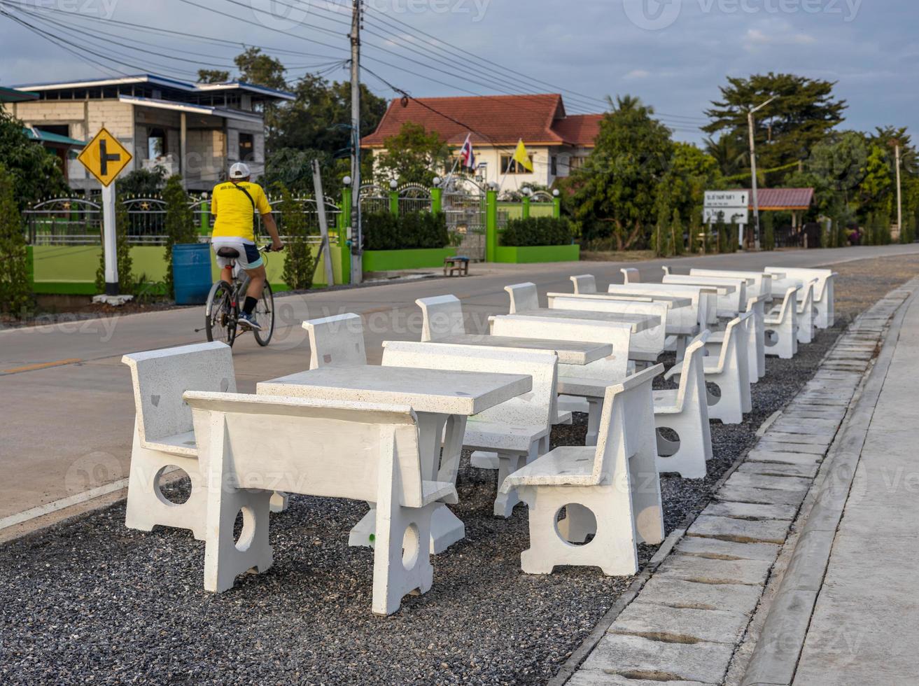 Views of rows of white marble tables and chairs lined up on the paved stone floor paved a way. photo