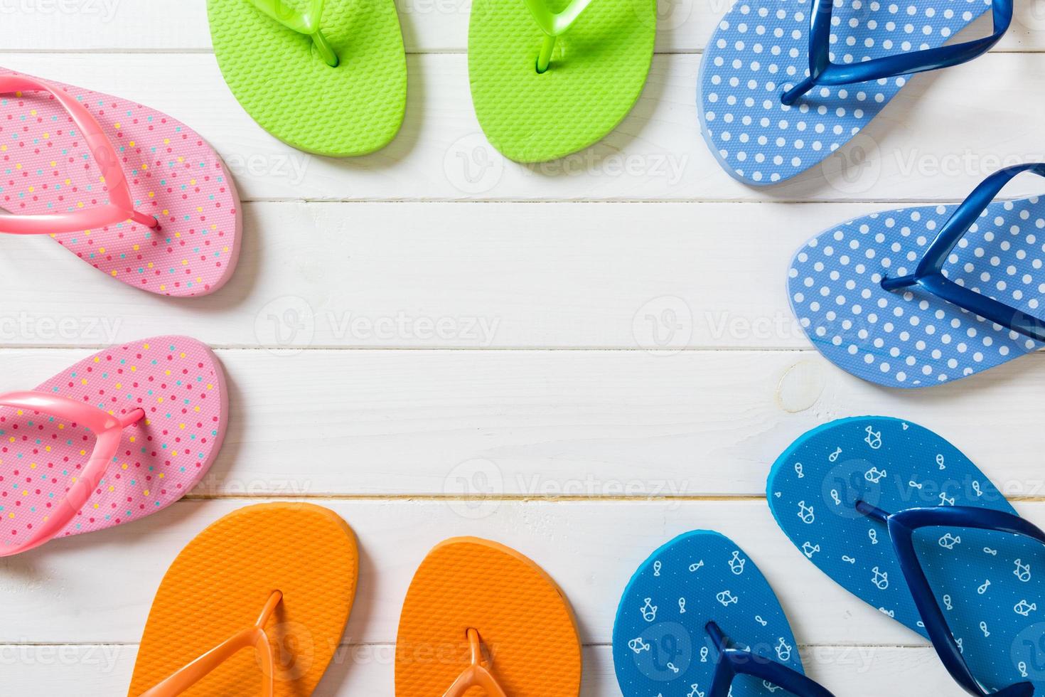 a lot of flip flop colored sandals, summer vacation on wooden background, copy space top view photo