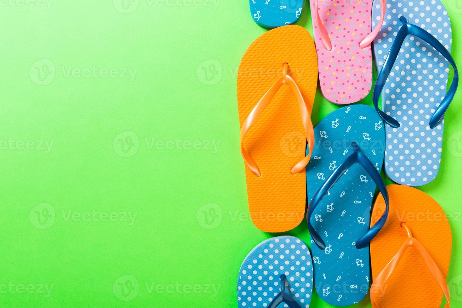 a lot of flip flop colored sandals, summer vacation on colored background, copy space top view photo