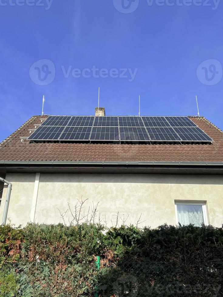 hogar solar panel. alternativa energía es usado para calefacción y agua calefacción. Respetuoso del medio ambiente alternativa energía para casa. residencial familia casa suburbano. marrón loseta techo de hogar con solar paneles foto