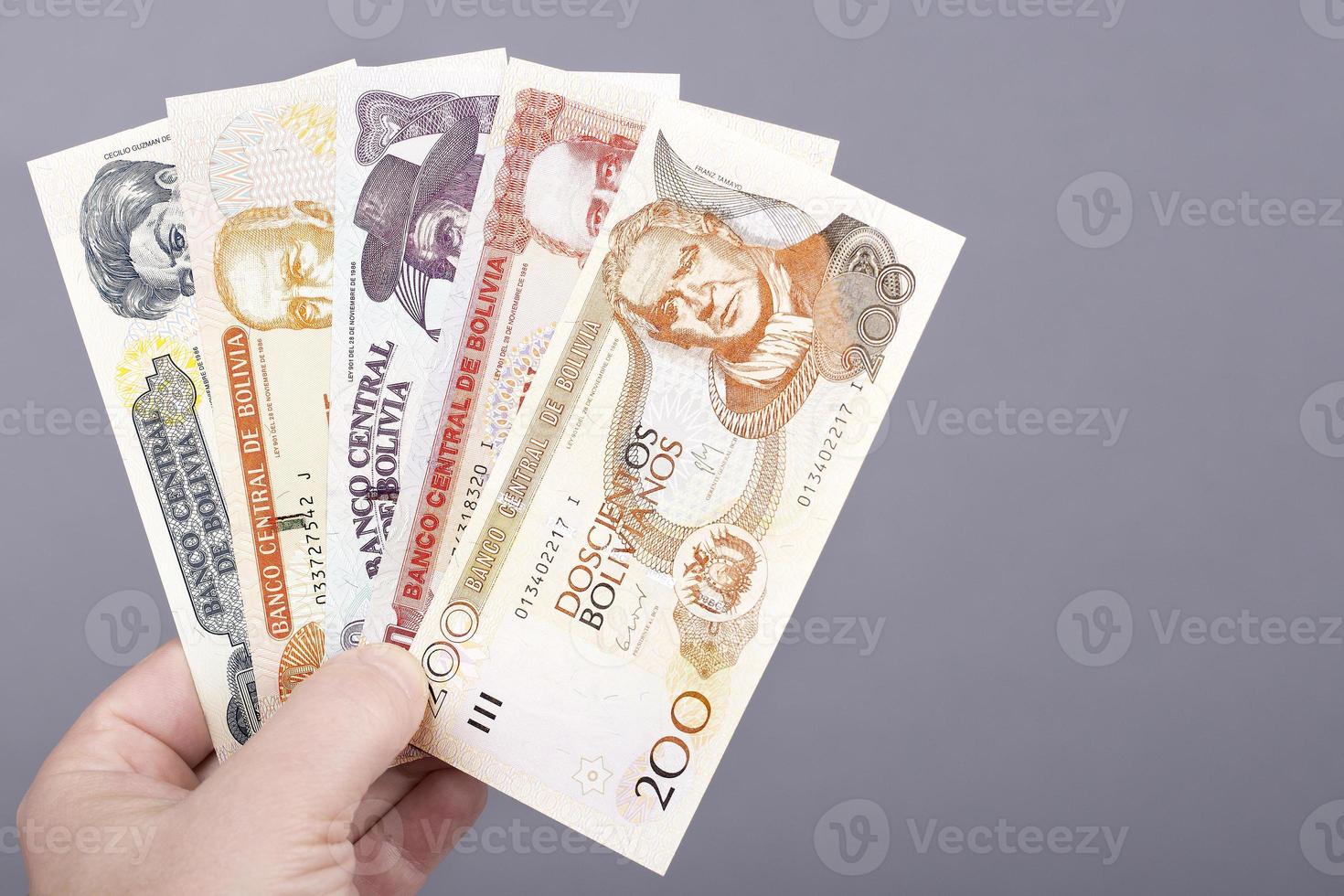 Bolivian money in the hand on a gray background photo
