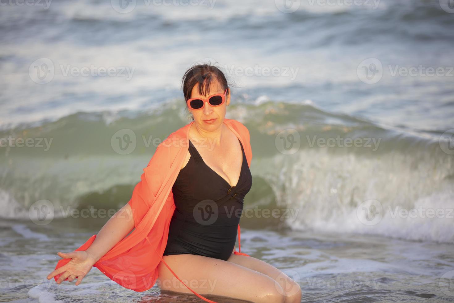 Woman in a swimsuit on a background of the sea.Portrait of a senior woman bathing in the sea photo