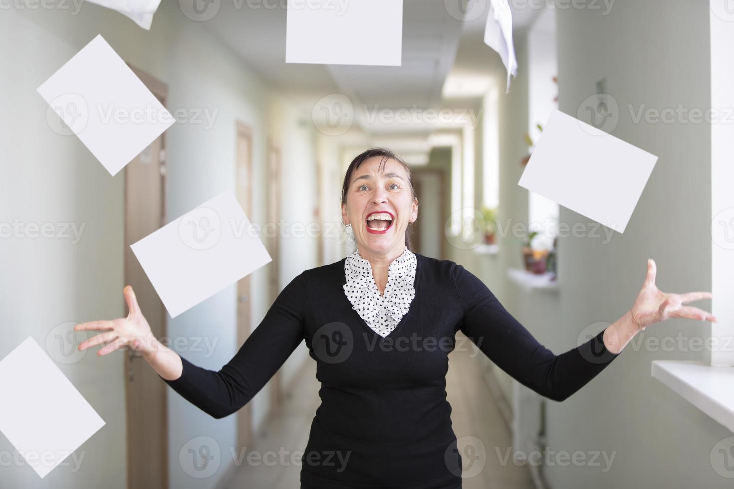 A woman in the office scatters papers. Nervous employee. photo