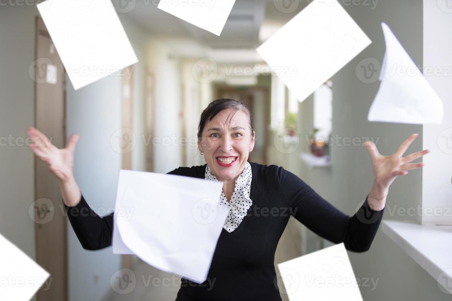 A woman in the office scatters papers. Nervous employee. photo