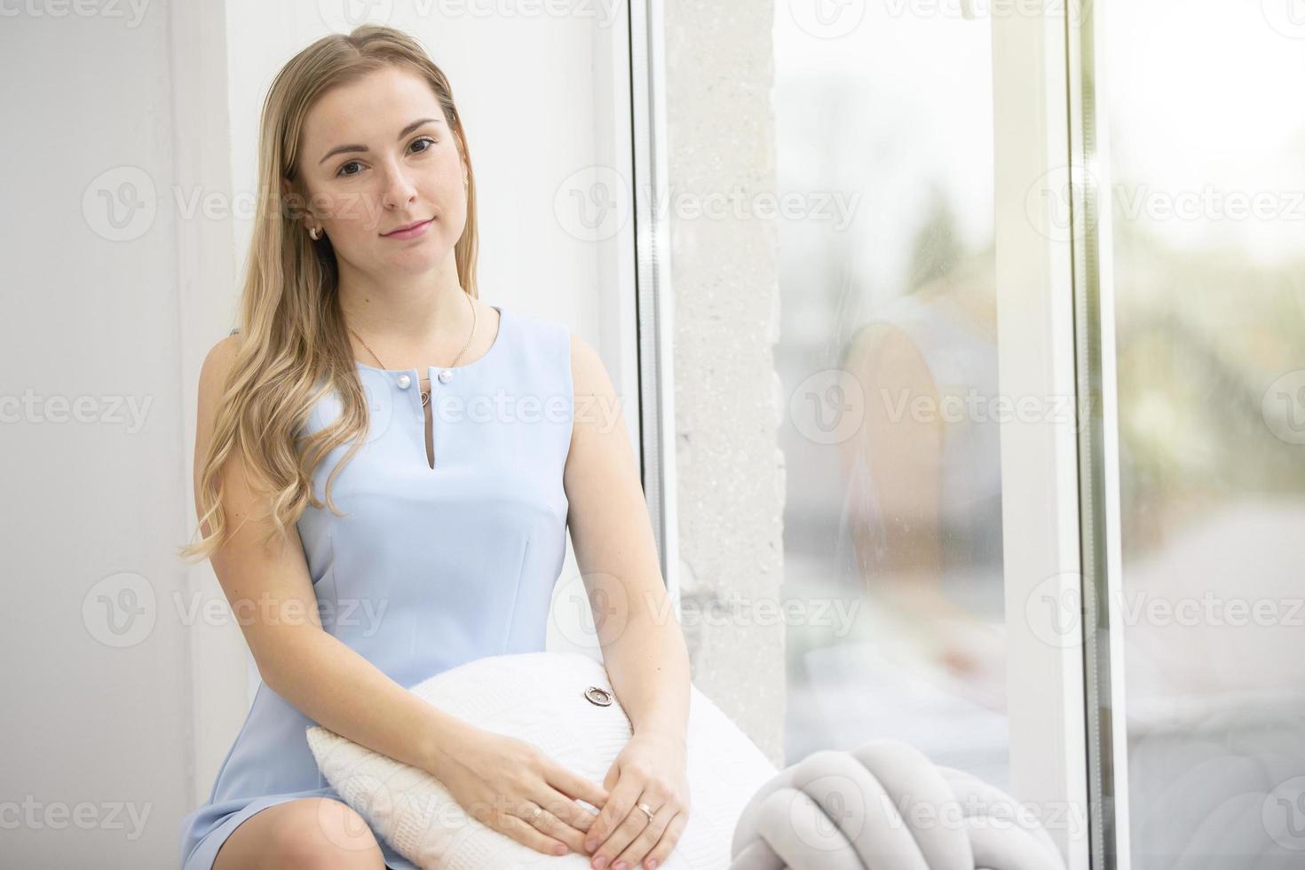 joven ordinario mujer a hogar cerca el ventana. foto