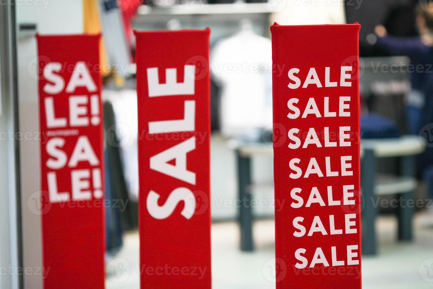 Red bright sale banner on anti-thieft gate sensor at retail shopping mall entrance. Seasonal discount offer in store. photo